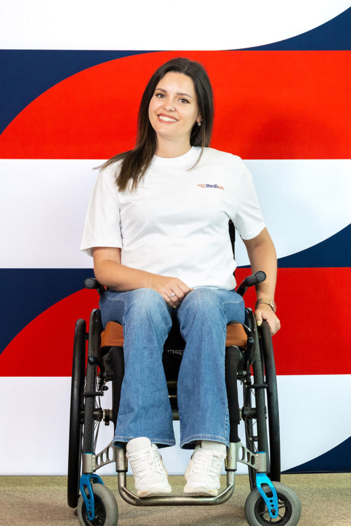 Woman in wheelchair sits and looks at the camera